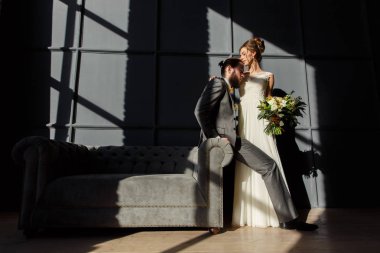 Gelin Damat kanepe ve koluna oturan sarılıyor. Onlar tarafından penceresinden sert ışık yanıyor