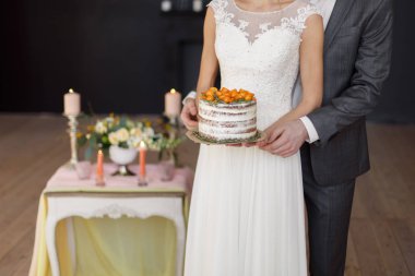 Gelin ve Damat Düğün pastası dekore edilmiş bir tablo elinde tut