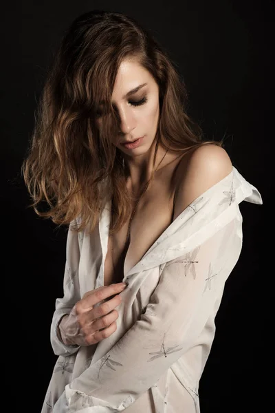 Retrato de morena sexy com cabelos longos em camisa branca aberta sem roupa interior e um ombro nu — Fotografia de Stock