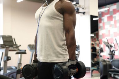 Kaslı zenci Beyaz tişört, spor salonunda dumbbells ile yapıyor