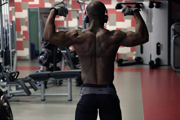 Atleta musculoso culturista posando en el gimnasio . — Foto de Stock