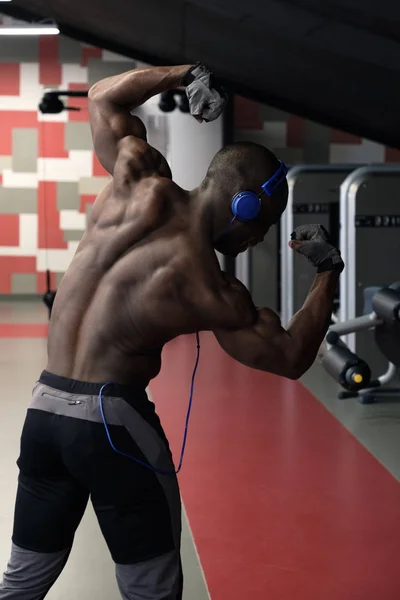 Hombre guapo con grandes músculos, posando en la cámara en el gimnasio — Foto de Stock