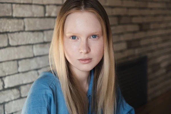 Close-up van portret van een jonge blonde meisje in een blauw shirt — Stockfoto