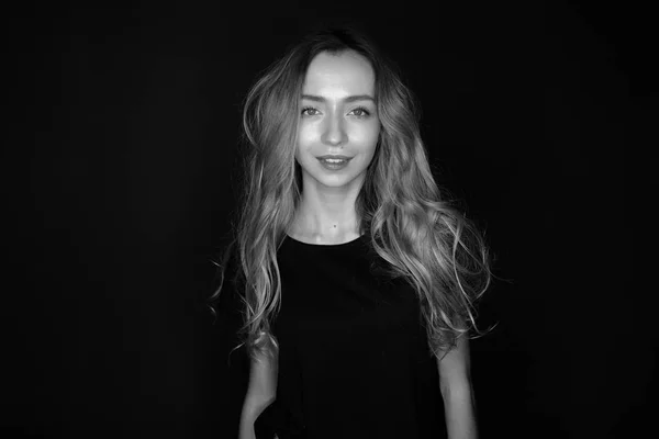 Black-and-white portrait of a barefoot girl blondes in a t-shirt and jeans model tests.