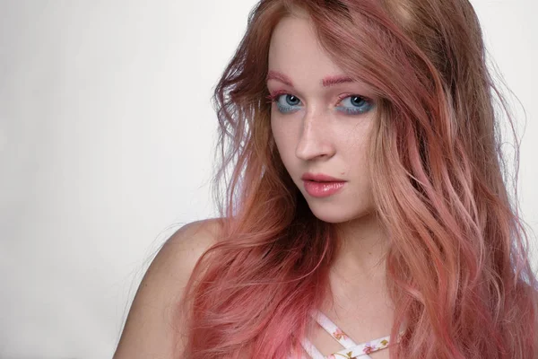 Close-up portret van meisje met roze haar en roze-en-blauw make-up op lichte achtergrond — Stockfoto