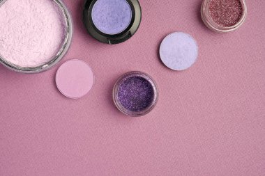 Göz farı ve toz, kirli pembe desenli arka planda üst köşeye konur.