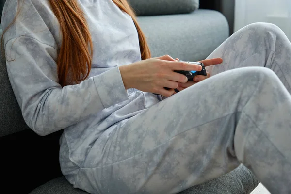 Sluiten frame van de handen van een meisje in pyjama met een spel joystick — Stockfoto
