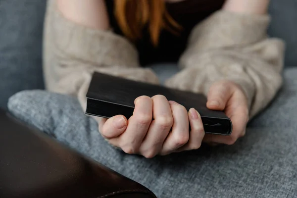 Sluiten foto van vrouwen handen met een zwart boek, focus op vingers. — Stockfoto