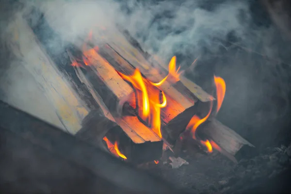 Queimando troncos para acender um fogo, chama e fumaça em chamas. Logs em um churrasco para fritar carne . — Fotografia de Stock
