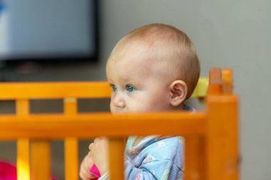 Çalışan bir televizyonun yanındaki çocuk oyun odasında küçük bir çocuk..