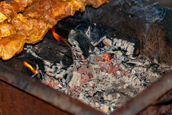 La carne arrosto sugli spiedini viene cotta su carboni ardenti . — Foto Stock