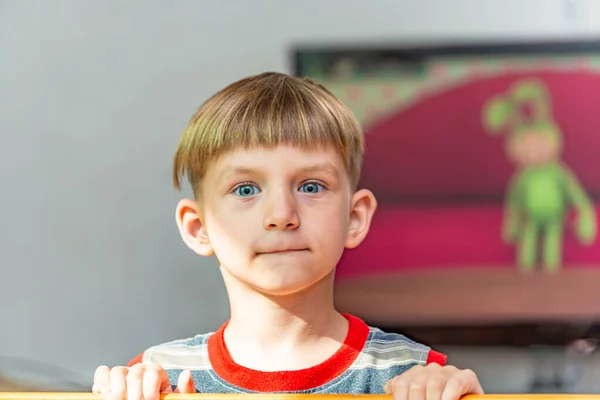 Der Junge steht mit dem Rücken zum Fernseher, das Kind will keine Karikaturen sehen. — Stockfoto