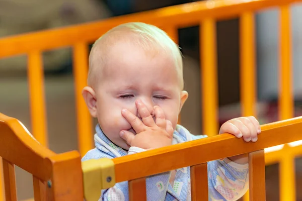 Ett litet barn täcker sitt ansikte med handen. — Stockfoto
