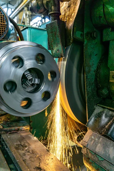A round part with holes is ground on a machine — Stock Photo, Image