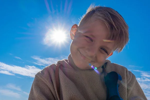 Portret chłopca na tle słońca na łonie natury. — Zdjęcie stockowe