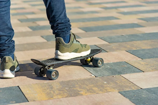 Ein Mann steht auf einem Bein auf einem Skateboard und bereitet sich auf ein Rennen vor. — Stockfoto