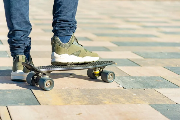 Ein Mann steht auf einem Bein auf einem Skateboard und bereitet sich auf ein Rennen vor. — Stockfoto