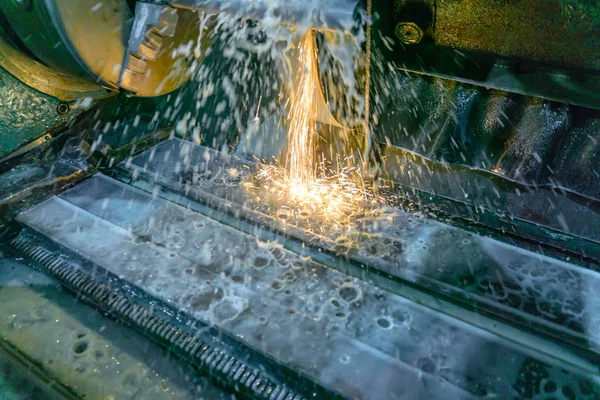 Шлифовальный станок для обработки металла с абразивными инструментами в производстве с охлаждением и искрами . — стоковое фото