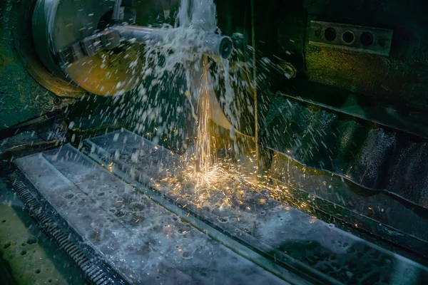 Шлифовальный станок для обработки металла с абразивными инструментами в производстве с охлаждением и искрами . — стоковое фото
