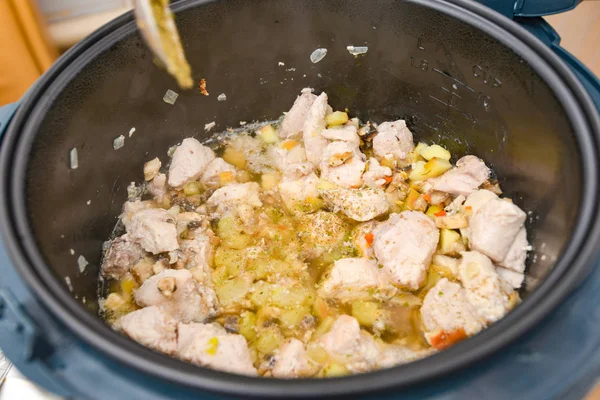 Woman adds spices for cooking meat in a slow cooker. — 图库照片