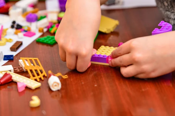 Los niños juegan en un diseñador infantil y construyen diferentes figuras de él . — Foto de Stock
