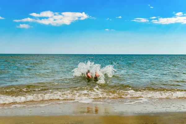 Pojken hoppar och dyker i havet. — Stockfoto