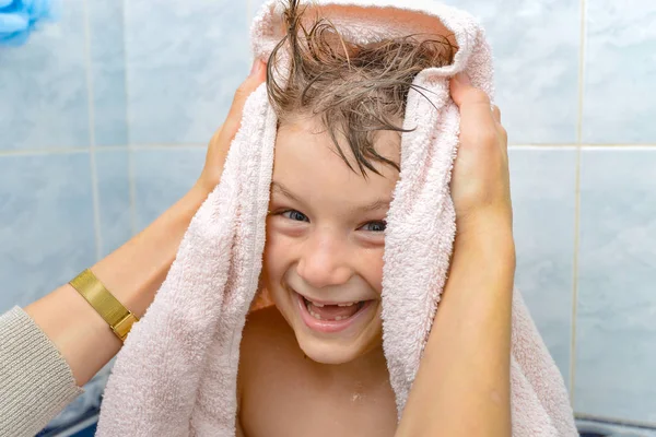 Мама вытирает ребенка полотенцем после купания в душе, радостный и счастливый мальчик в ванной — стоковое фото