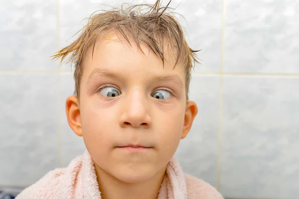 Удивленный ребенок после купания в душе, сумасшедший мальчик в ванной — стоковое фото