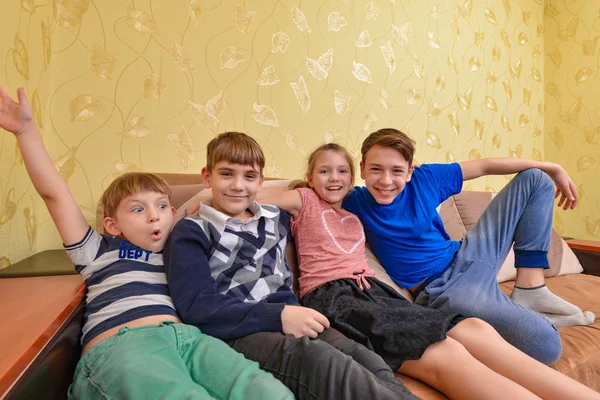 Bratři a sestry na gauči, děti v místnosti zvednou ruce — Stock fotografie
