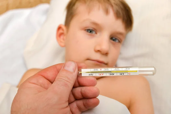 Le médecin montre une température élevée sur le thermomètre d'un enfant froid — Photo