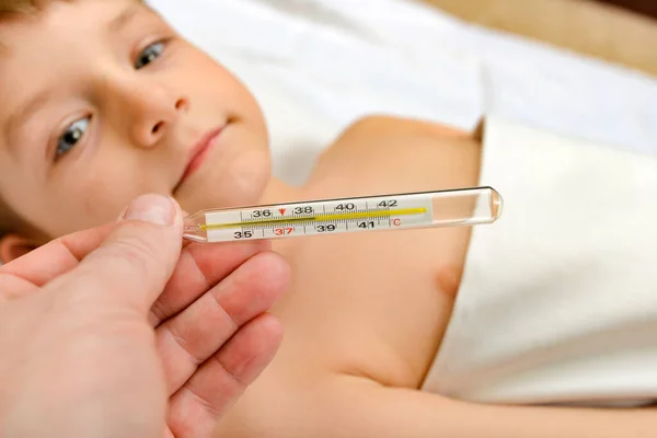El médico muestra una alta temperatura en el termómetro de un niño frío —  Fotos de Stock