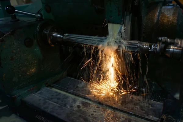 Slijpen en hoge precisie asverwerking op een cirkelvormige slijpmachine met vonken en koeling. — Stockfoto