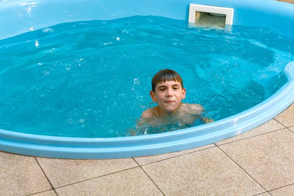 Dziecko w domowym basenie kąpie się i nurkuje w wodzie. — Zdjęcie stockowe