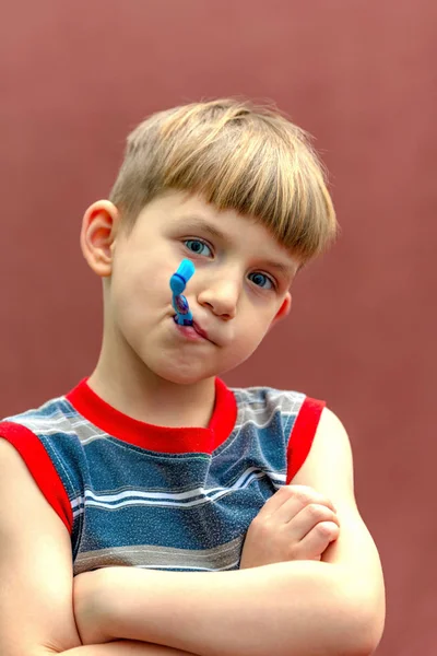 A criança segura uma escova de dentes na mão perto da boca . — Fotografia de Stock