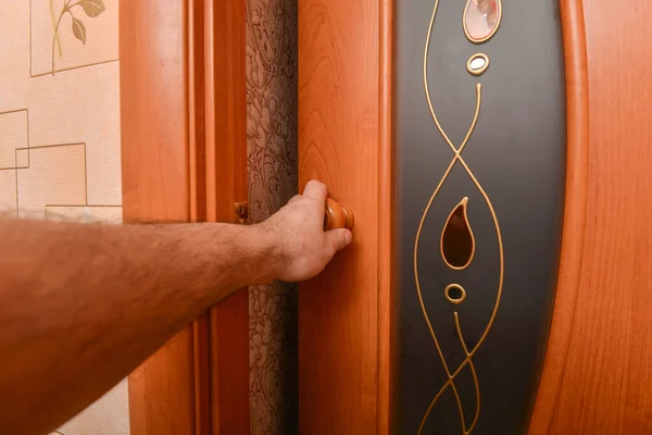 Ein Mann öffnet die Tür mit dem Griff zum Ausgang. — Stockfoto