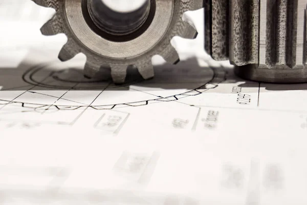 Duas engrenagens após a fabricação em uma máquina CNC estão no desenho, close-up . — Fotografia de Stock