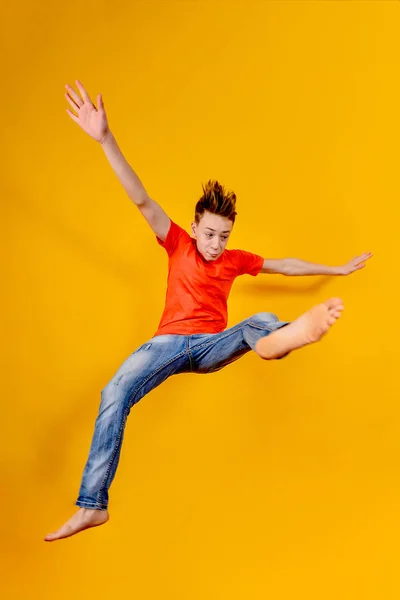 Funny and crazy boy jumps up on a yellow background, wide angle photo. — Stok fotoğraf