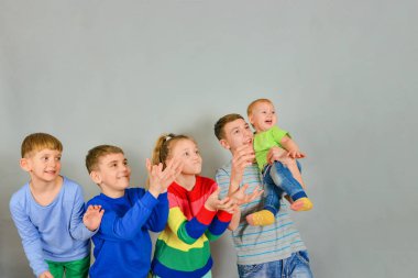 Joyful and surprised children catch a falling object from above. The rivalry between the children who first catch.