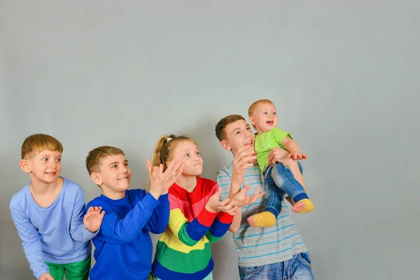 Joyful and surprised children catch a falling object from above. The rivalry between the children who first catch. — Stockfoto