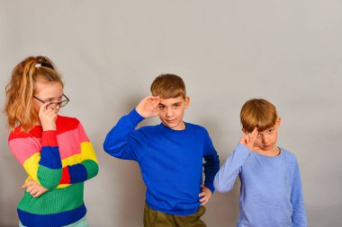 The girl with glasses and her two younger brothers show their respect and love for their sister.