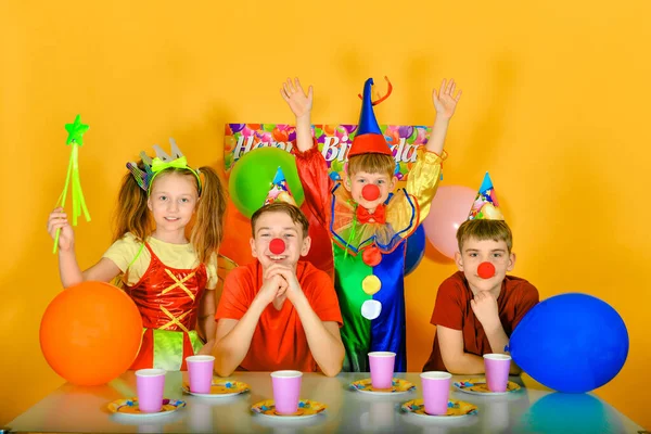 Quatro Crianças Com Palhaço Mesa Festiva Levantem Mãos — Fotografia de Stock