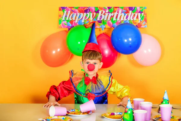 Uma Criança Vestida Palhaço Sentada Mesa Festiva Fundo Levantando Balões — Fotografia de Stock