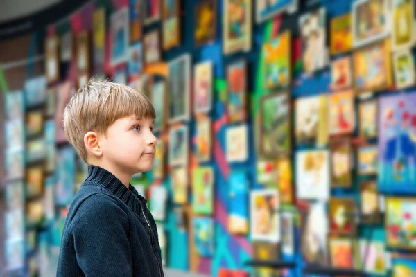 Sanat galerisinde bir çocuk sanatı inceliyor..