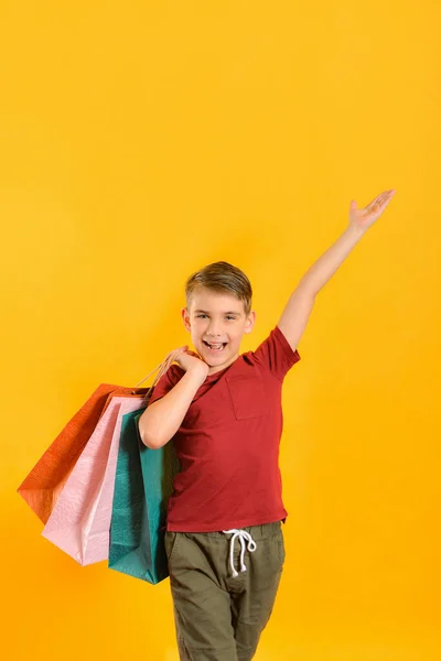 Chłopiec Torbami Żółtym Tle Koncepcja Zakupów — Zdjęcie stockowe