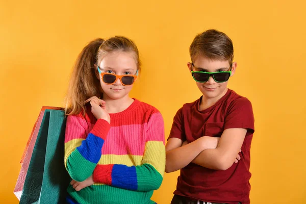 Niño Niña Gafas Sol Con Bolsas Compras Sobre Fondo Amarillo —  Fotos de Stock