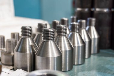 Bir makine atölyesindeki askıda vidalar ve vidalar..