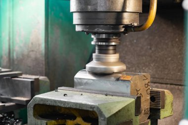 Hızlı lehimlemeli hızlı kesim yapan bir değirmen CNC makinesinde metal çıkartıyor, kenarlarda çipler uçuşuyor..