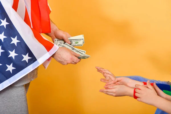 Amerikan Bayrağı Altındaki Bir Adamın Eli Parayı Çocukların Ellerine Teslim — Stok fotoğraf