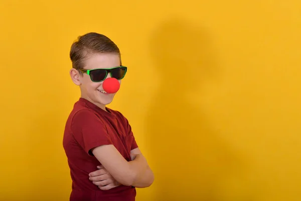 Серйозний Хлопчик Клоунним Носом Стоїть Жовтому Тлі Складеними Руками Біля — стокове фото
