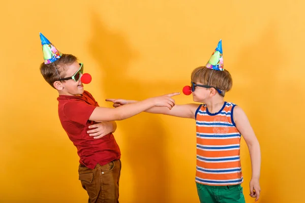 Zwei Jungen Festlichen Mützen Mit Clownsnase Und Sonnenbrille Zeigen Mit — Stockfoto